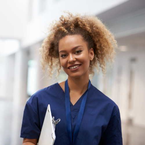 Portrait Of Female Nurse Wearing Scrubs In Hospital